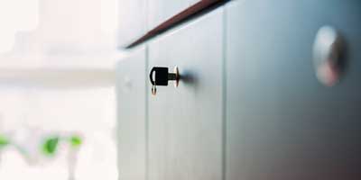 Key inserted in the lock of a metal office filing cabinet
