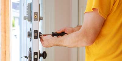 Residential locksmith installing a lock on the edge of a home front door